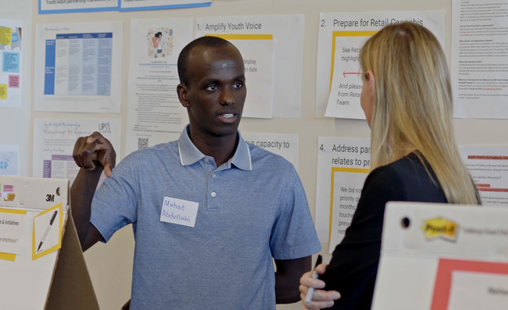 Mahat Abdullahi talks with a participant a the summit for the Northwest Vermont Regional Prevention Network